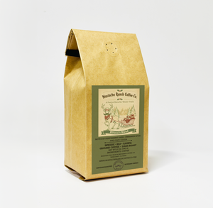 Mustache Ranch Coffee Co. Blitzen Blend dark roast coffee in a kraft paper bag with a festive reindeer sleigh illustration and green holiday-themed branding on a white background.