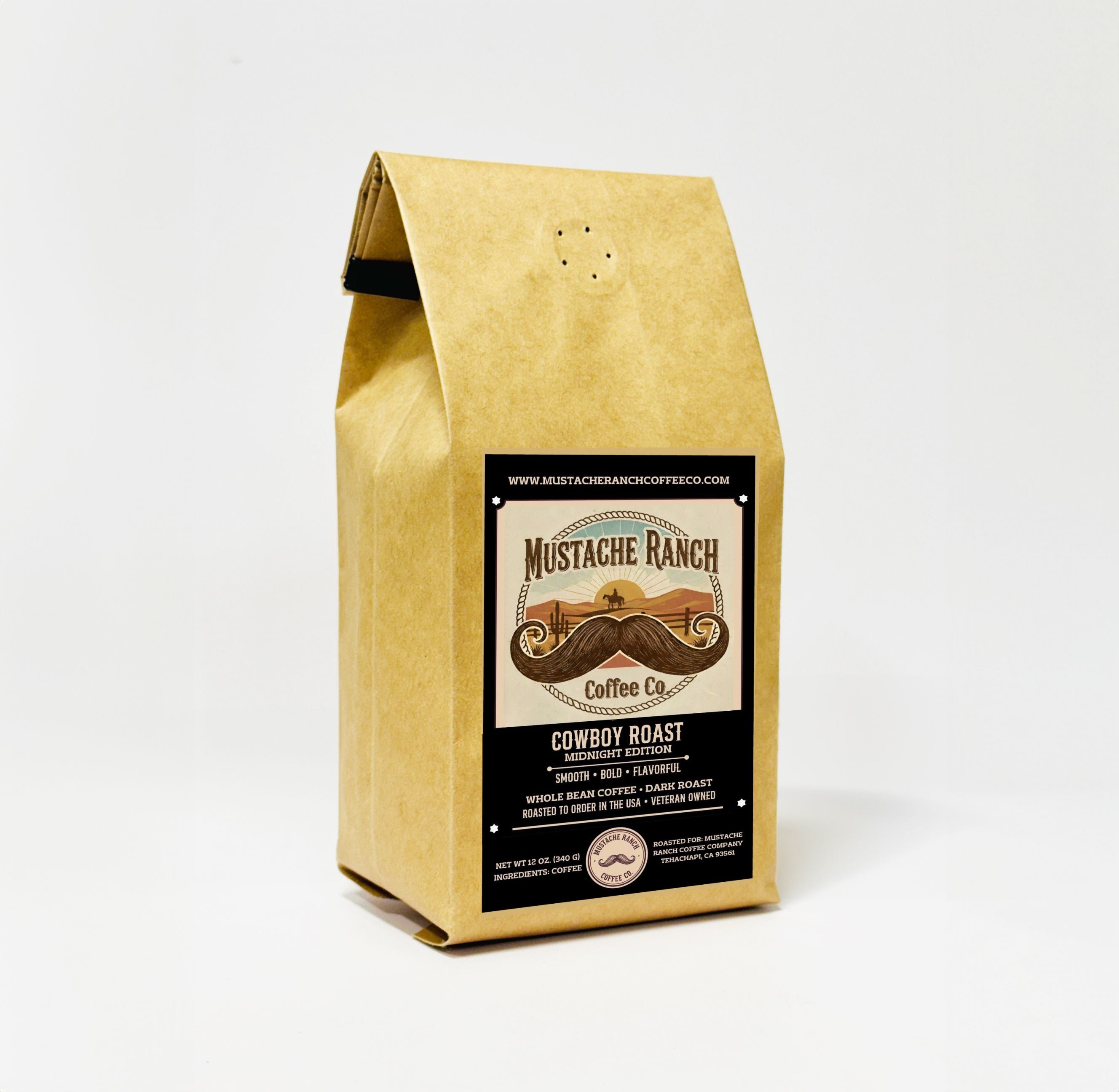 A 12 oz craft paper bag of Mustache Ranch Coffee Co. Cowboy Roast: Midnight Edition dark roast coffee. The bag is standing upright against a clean, plain white background, featuring a bold black product label with a western sunset scene, a large mustache graphic, and text indicating it is smooth, bold, flavorful, whole bean, veteran-owned, and roasted to order in the USA.