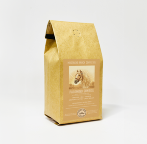 Mustache Ranch Coffee Co. Palomino Sunrise light roast coffee in a kraft paper bag with a palomino horse illustration and western-style branding on a white background.
