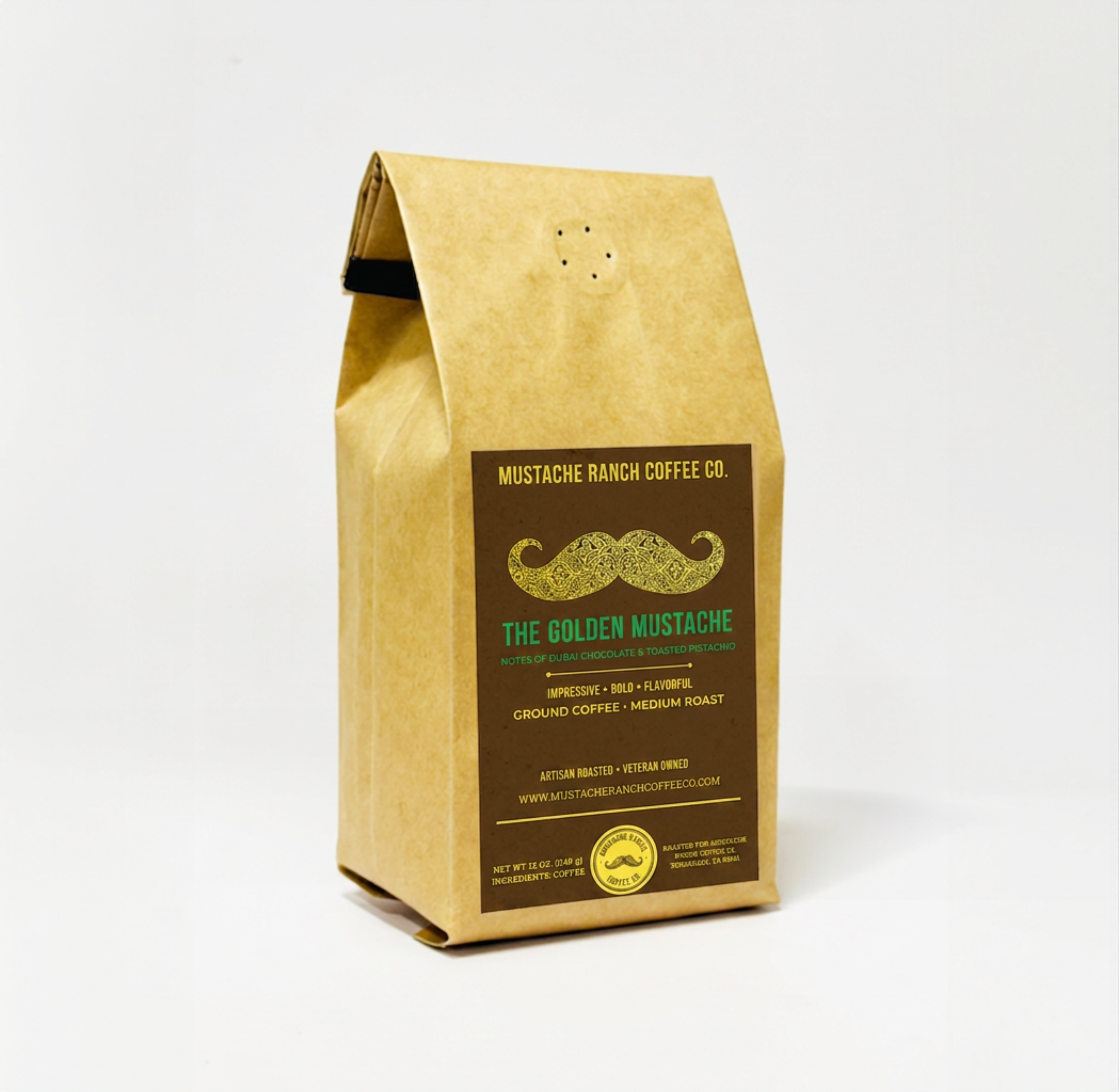 A 12oz kraft paper bag of Mustache Ranch Coffee Co. "The Golden Mustache" medium roast ground coffee. The brown label features a gold filigree mustache and highlights flavor notes of Dubai chocolate and toasted pistachio.