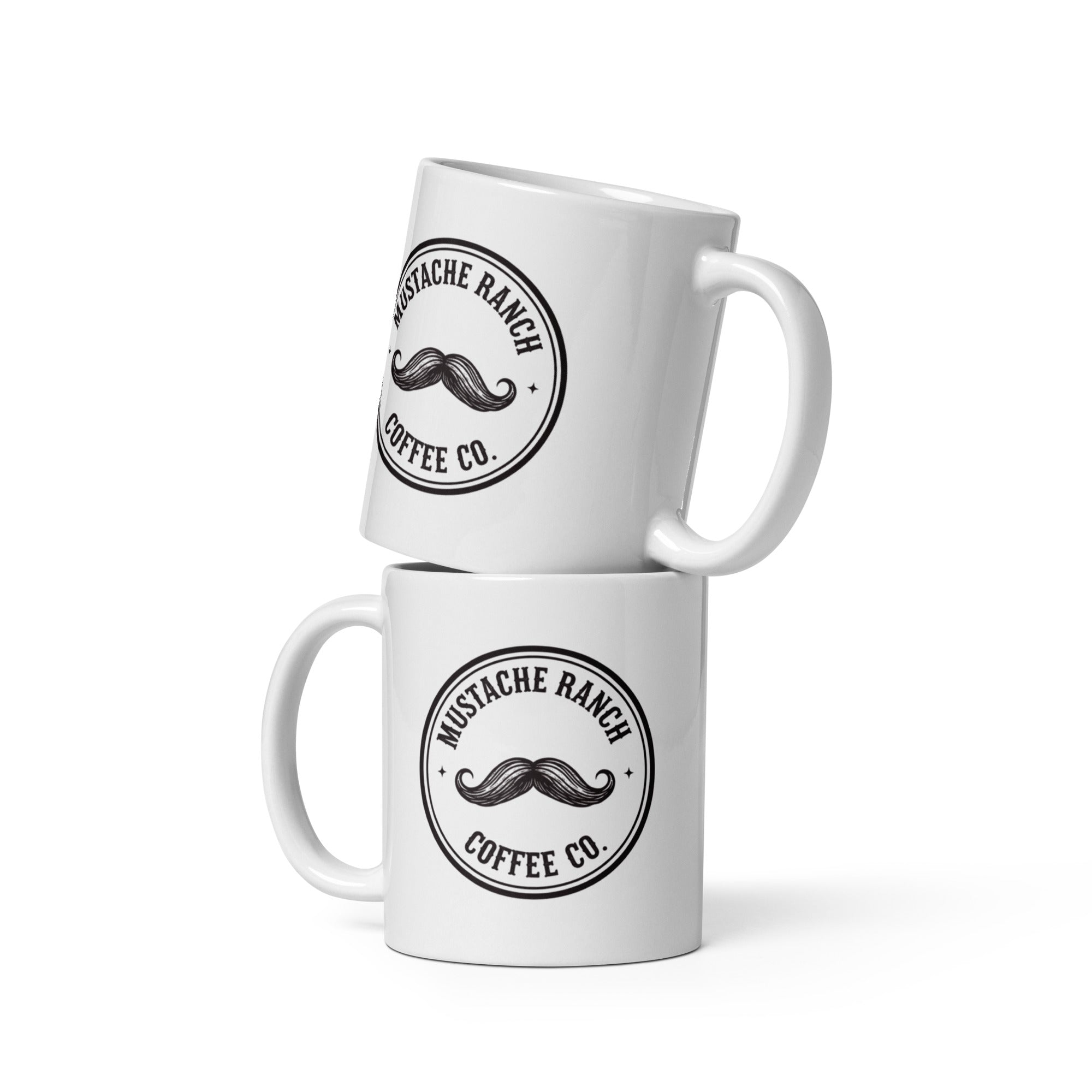 Two white glossy ceramic Mustache Ranch Coffee Co. mugs stacked vertically, featuring the black logo, displayed on a clean white background.