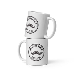 Two white glossy ceramic Mustache Ranch Coffee Co. mugs stacked vertically, featuring the black logo, displayed on a clean white background.